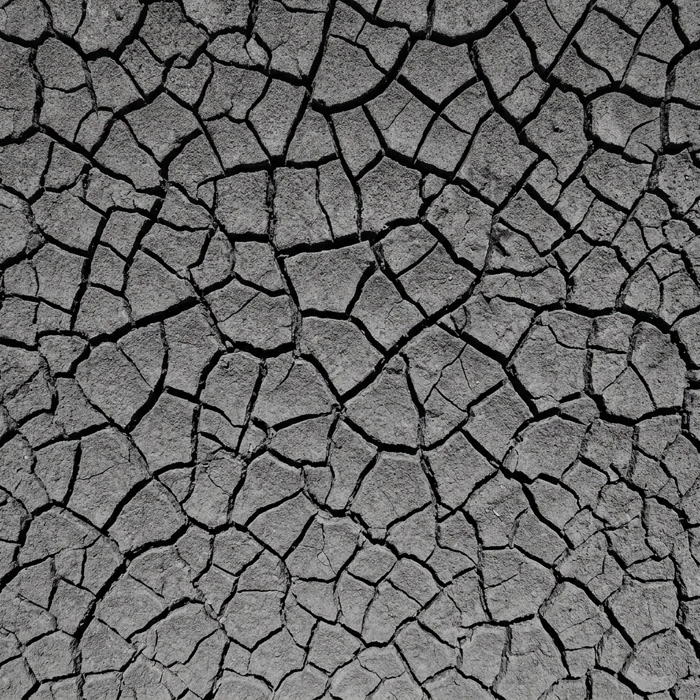 Overhead view of deeply cracked grey clay floodplain soil forming geometric patterns